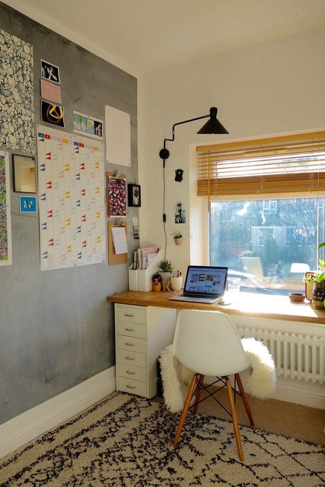 This is an example of a small scandinavian study room in Other with white walls, carpet, no fireplace and a freestanding desk.