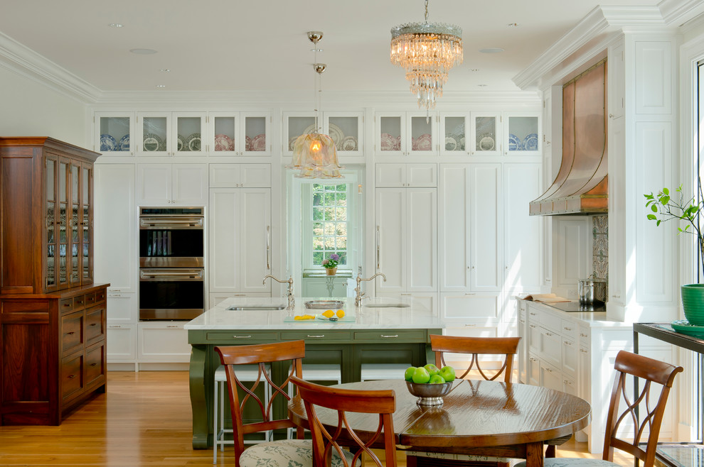 Photo of a large traditional l-shaped eat-in kitchen in Baltimore with an undermount sink, shaker cabinets, white cabinets, panelled appliances, medium hardwood floors and with island.