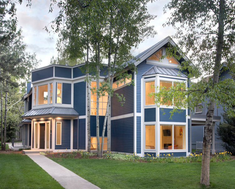 Idées déco pour une façade de maison bleue contemporaine en bois de taille moyenne et à un étage avec un toit à croupette, un toit mixte et un toit bleu.