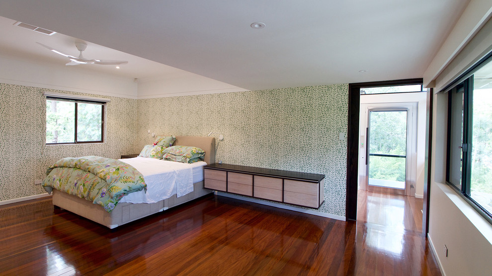 Large contemporary master bedroom in Brisbane with green walls, dark hardwood floors and brown floor.