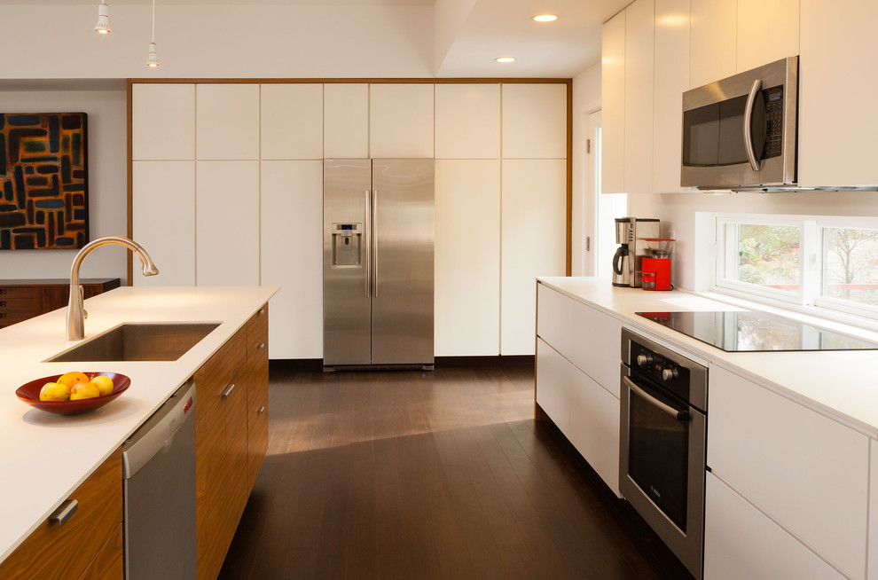 Modern kitchen in Atlanta with an undermount sink, flat-panel cabinets, white cabinets and stainless steel appliances.