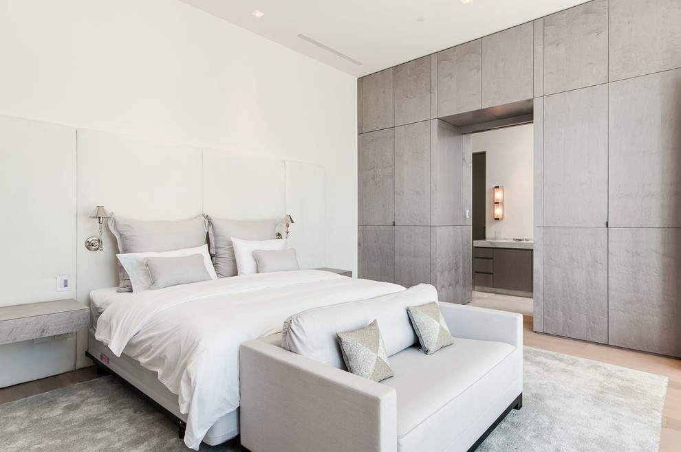 Photo of a large contemporary master bedroom in Miami with white walls, light hardwood floors, no fireplace and white floor.