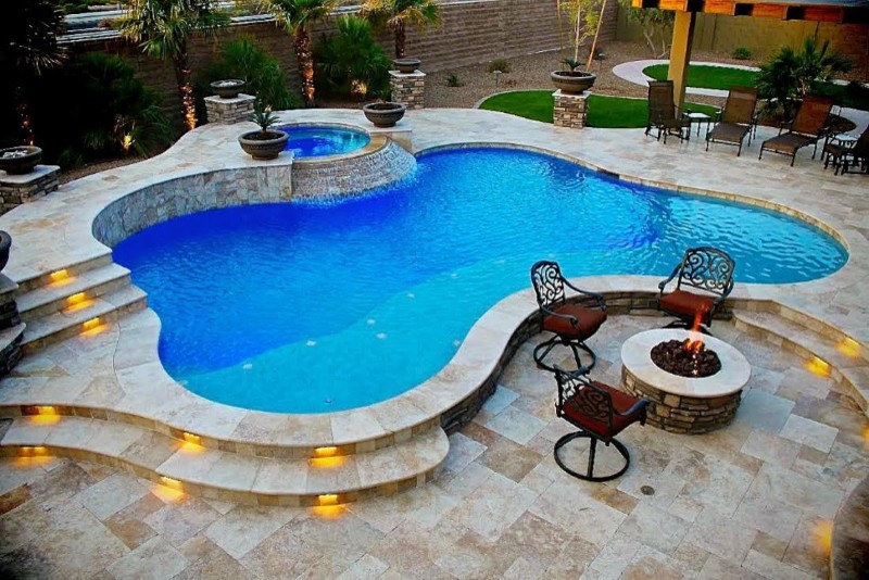 Design ideas for a mid-sized contemporary backyard custom-shaped lap pool in Orange County with a water feature and natural stone pavers.