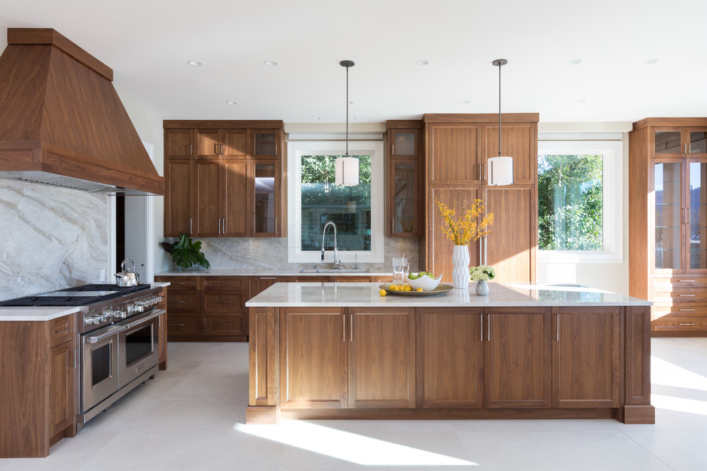 Large contemporary l-shaped open plan kitchen in Vancouver with an undermount sink, shaker cabinets, medium wood cabinets, granite benchtops, beige splashback, stone slab splashback, panelled appliances, limestone floors, with island and white floor.