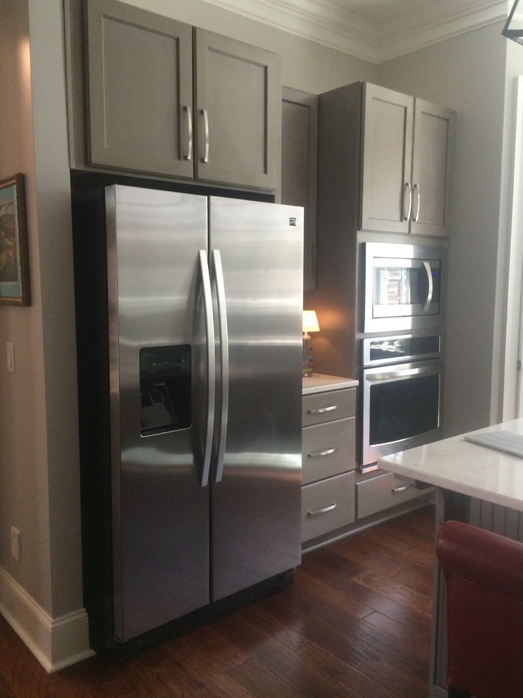 Inspiration for a mid-sized transitional single-wall dark wood floor open concept kitchen remodel with shaker cabinets, dark wood cabinets, marble countertops, gray backsplash, glass tile backsplash, stainless steel appliances and an island