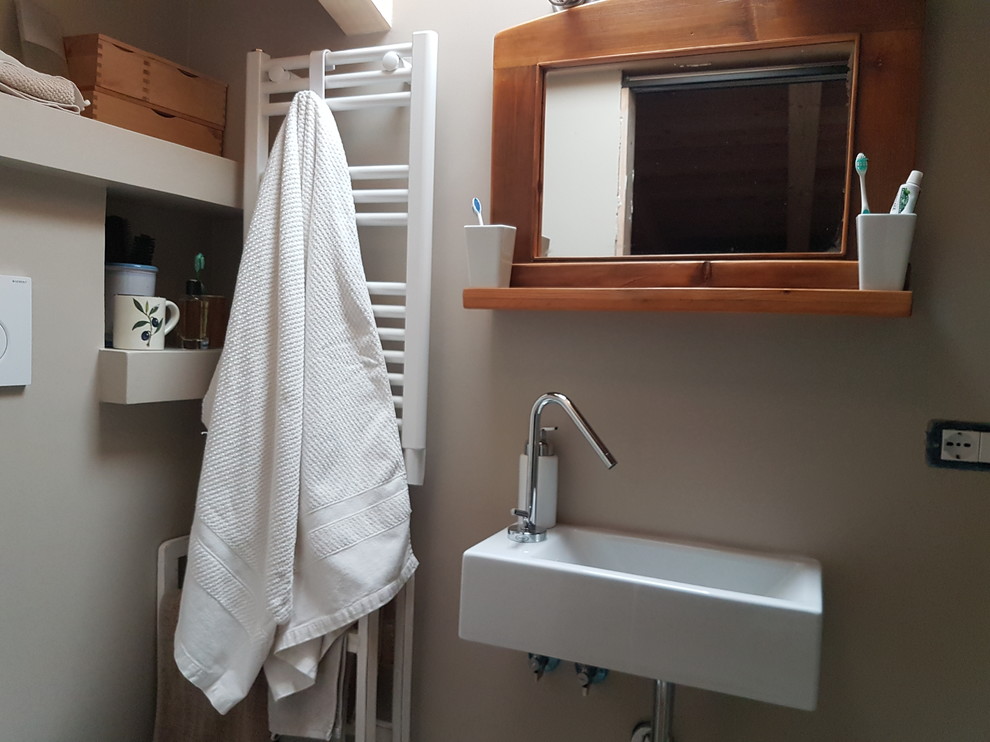 This is an example of a small country 3/4 bathroom in Rome with dark wood cabinets, a wall-mount toilet, beige walls, a wall-mount sink and wood benchtops.