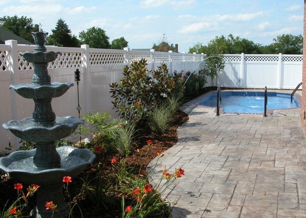 This is an example of a traditional backyard pool in Nashville with a water feature and stamped concrete.