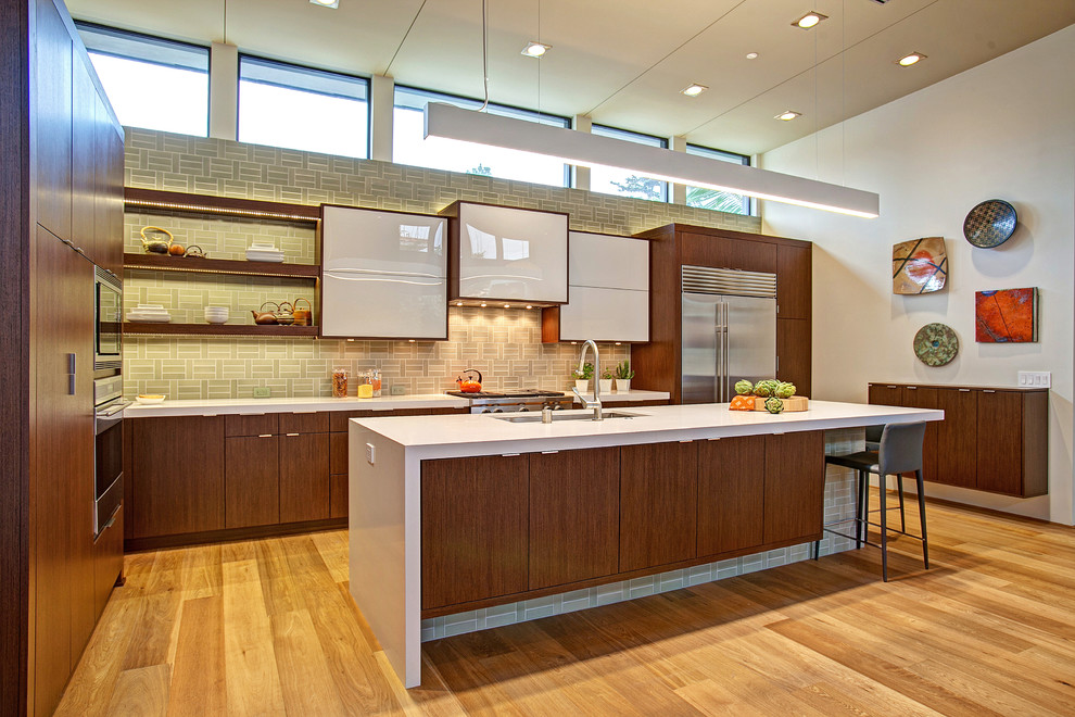 This is an example of a large midcentury l-shaped open plan kitchen in San Diego with an undermount sink, flat-panel cabinets, medium wood cabinets, quartz benchtops, grey splashback, ceramic splashback, stainless steel appliances, light hardwood floors and with island.