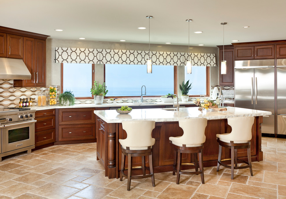 Design ideas for a large transitional u-shaped open plan kitchen in Orange County with medium wood cabinets, stainless steel appliances, an undermount sink, recessed-panel cabinets, multi-coloured splashback, travertine floors, with island, beige floor and white benchtop.