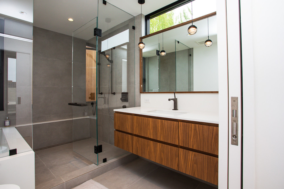 Inspiration for a mid-sized modern master bathroom in Portland with medium wood cabinets, white walls, cement tiles, grey floor, a hinged shower door, white benchtops, a single vanity, a floating vanity, flat-panel cabinets, a shower/bathtub combo and an undermount sink.