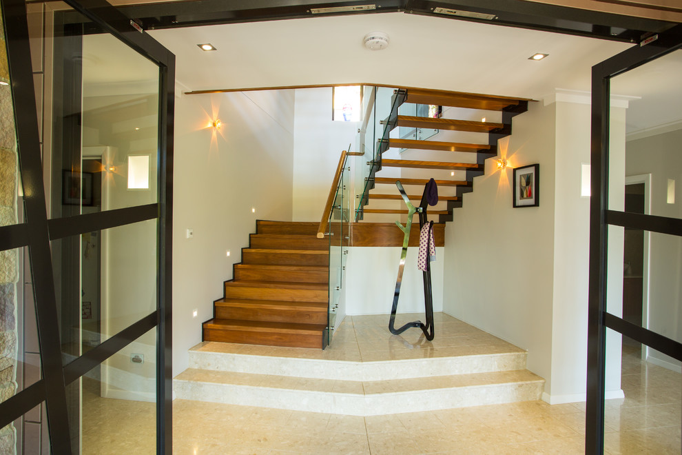 Design ideas for an expansive wood u-shaped staircase in Brisbane with wood risers.
