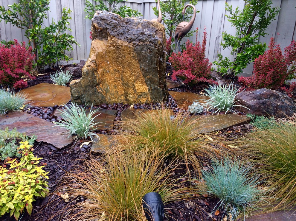 Inspiration for a small asian backyard full sun garden in Sacramento with a water feature.