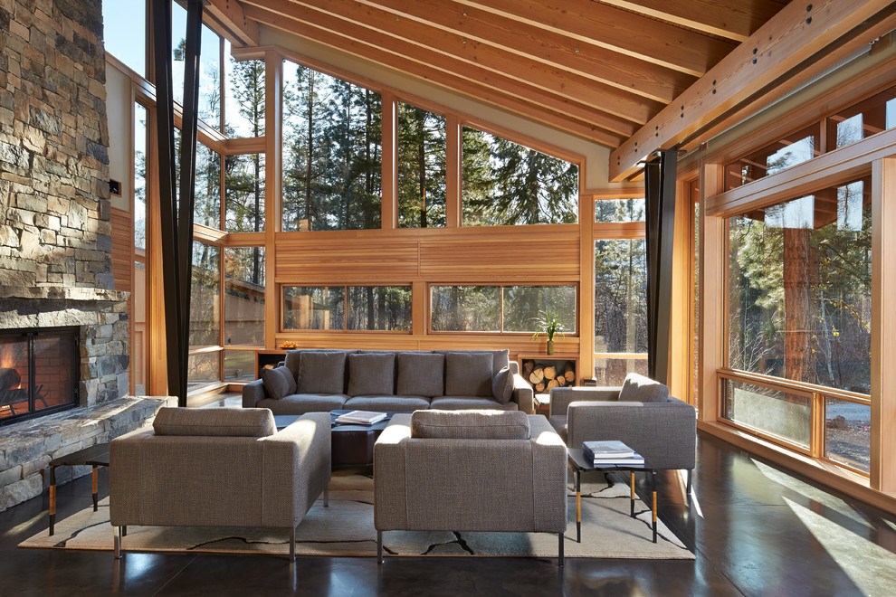 This is an example of a large contemporary formal open concept living room in Seattle with concrete floors, a standard fireplace and a stone fireplace surround.