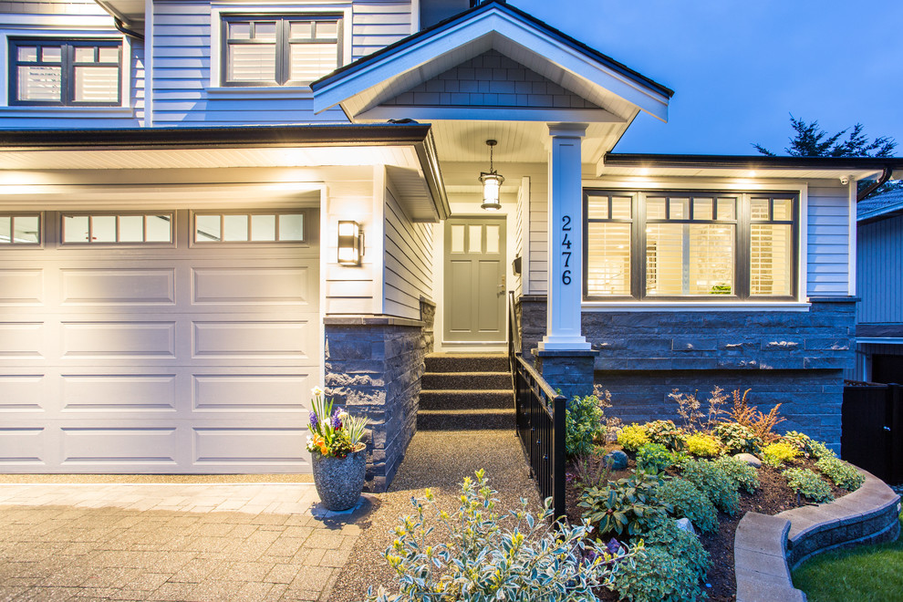 This is an example of a mid-sized traditional two-storey grey house exterior in Vancouver with mixed siding, a gable roof and a shingle roof.