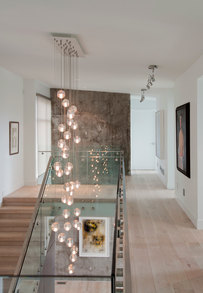 Inspiration for a contemporary hallway in Vancouver with white walls and light hardwood floors.