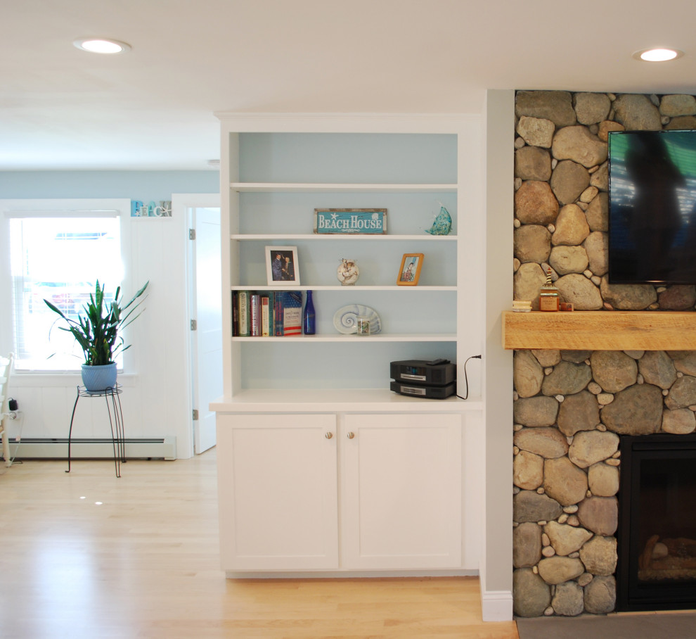 Источник вдохновения для домашнего уюта: открытая гостиная комната среднего размера в морском стиле с синими стенами, светлым паркетным полом, стандартным камином, фасадом камина из камня, телевизором на стене и панелями на стенах