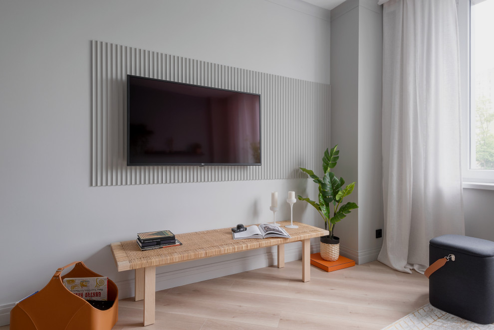 Идея дизайна: серо-белая гостиная комната среднего размера в современном стиле с серыми стенами, полом из ламината, телевизором на стене, бежевым полом и панелями на части стены