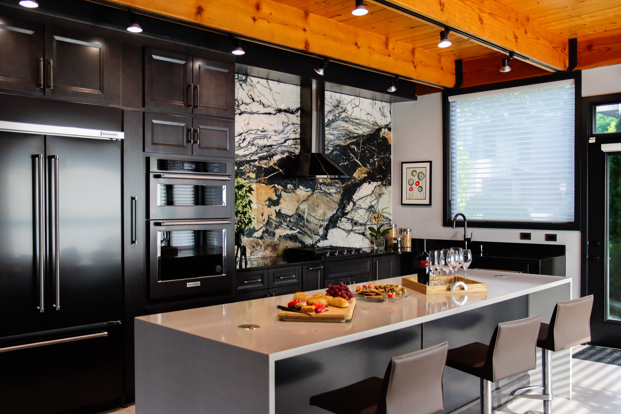 Modern, Contemporary kitchen remodel, renovation includes full height quartzite slab, dark cabinets,,white quartz island, light color LVP floors, black appliances, black counters, brown leather stools