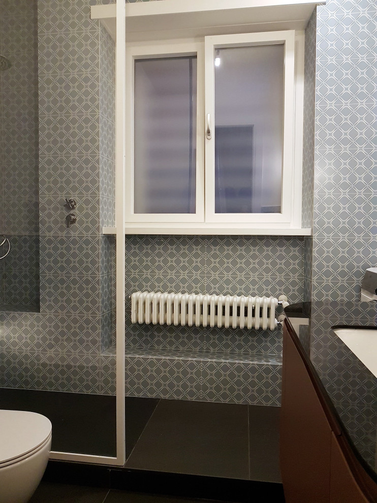 Photo of a mid-sized contemporary bathroom in Rome with flat-panel cabinets, red cabinets, a curbless shower, a two-piece toilet, beige tile, ceramic tile, white walls, porcelain floors, a vessel sink, glass benchtops, black floor, black benchtops, a niche, a single vanity and a floating vanity.