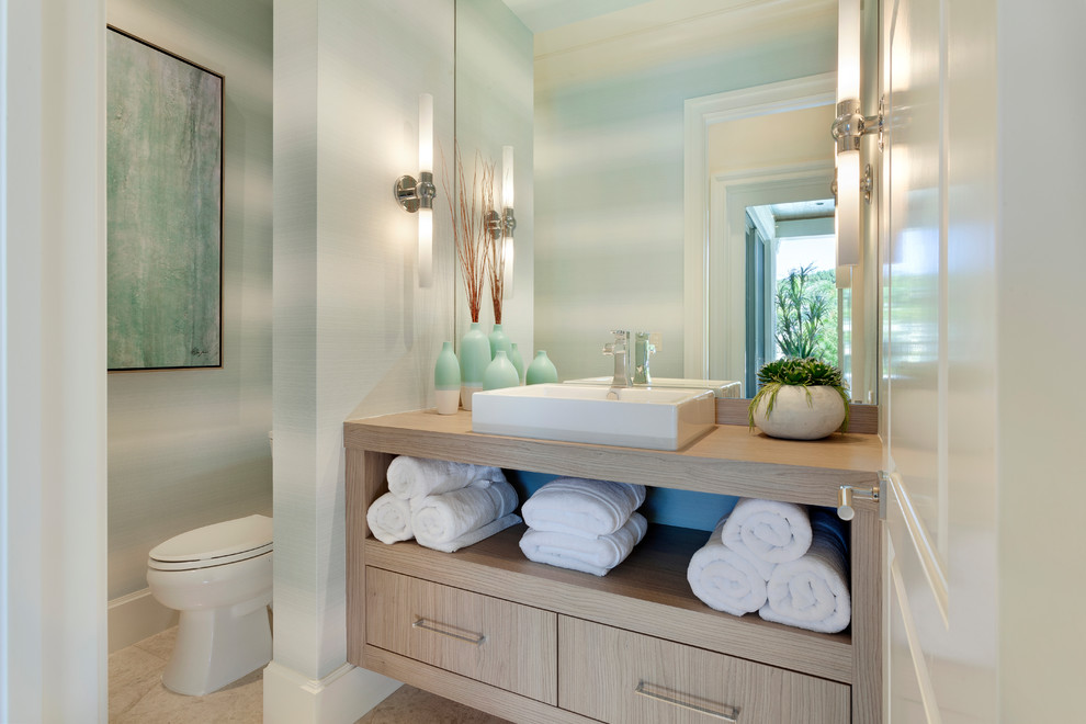 Beach style powder room in Miami with flat-panel cabinets, light wood cabinets, multi-coloured walls, a vessel sink, wood benchtops, beige floor and beige benchtops.