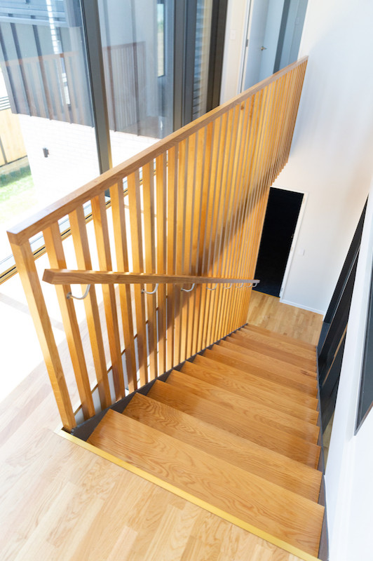 Imagen de escalera suspendida contemporánea de tamaño medio sin contrahuella con escalones de madera y barandilla de madera