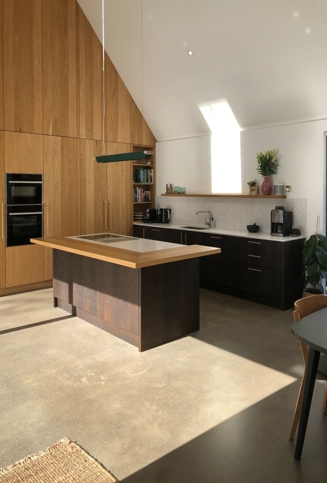 Cette image montre une salle à manger ouverte sur la cuisine minimaliste de taille moyenne avec un mur blanc, un sol gris et un plafond voûté.