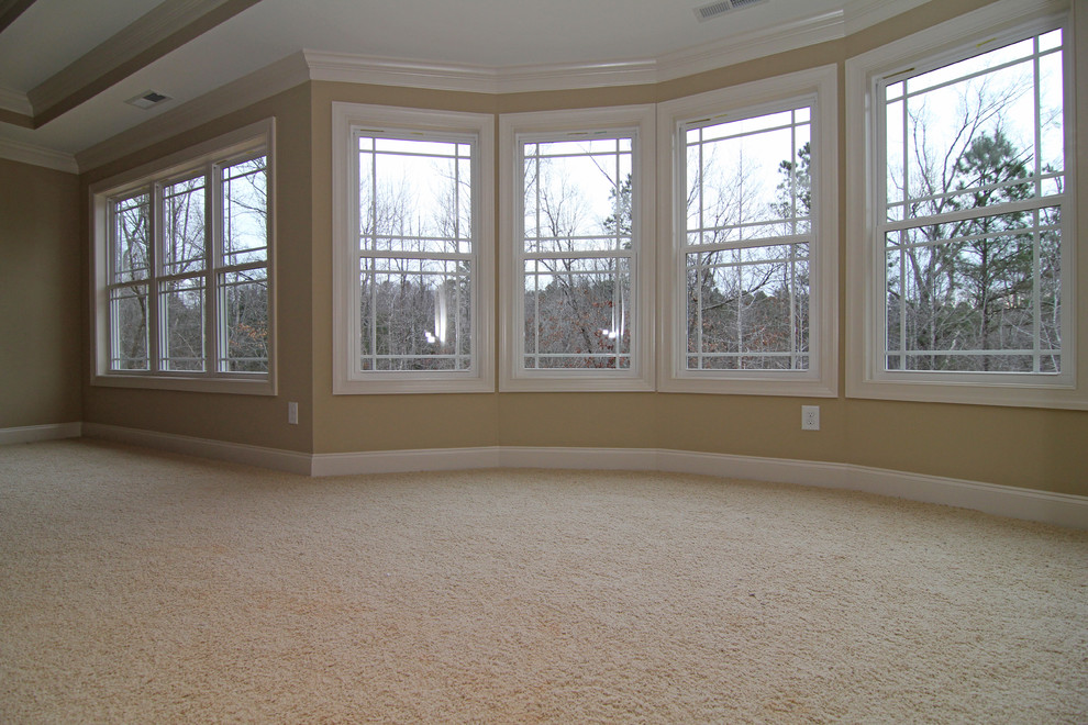 Inspiration for an expansive traditional master bedroom in Raleigh with beige walls and carpet.