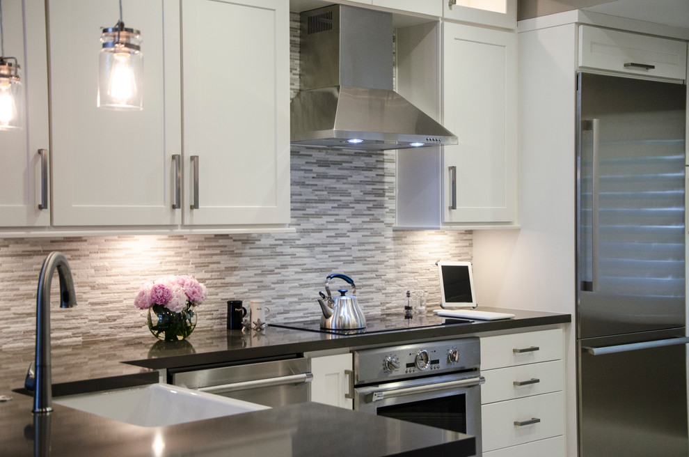 Example of a small transitional u-shaped porcelain tile kitchen design in Miami with a farmhouse sink, shaker cabinets, white cabinets, quartz countertops, gray backsplash, stone tile backsplash, stainless steel appliances and no island