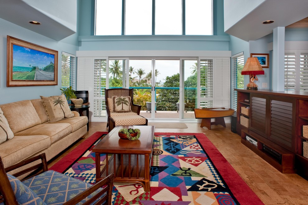 This is an example of a mid-sized tropical formal open concept living room in Hawaii with blue walls and brown floor.