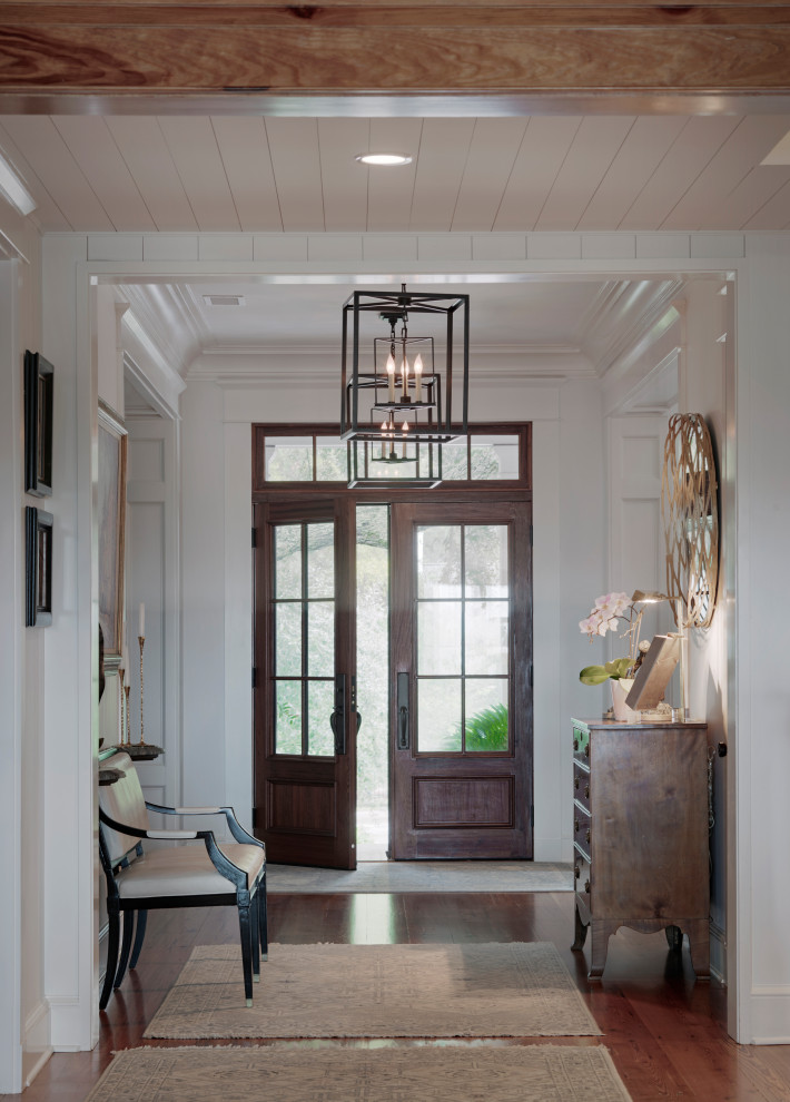 This is an example of a beach style entrance in Other with white walls, light hardwood flooring, white floors and a wood ceiling.