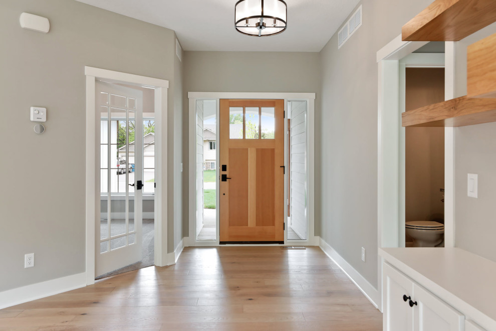Mid-sized cottage medium tone wood floor entryway photo in Minneapolis with gray walls and a medium wood front door