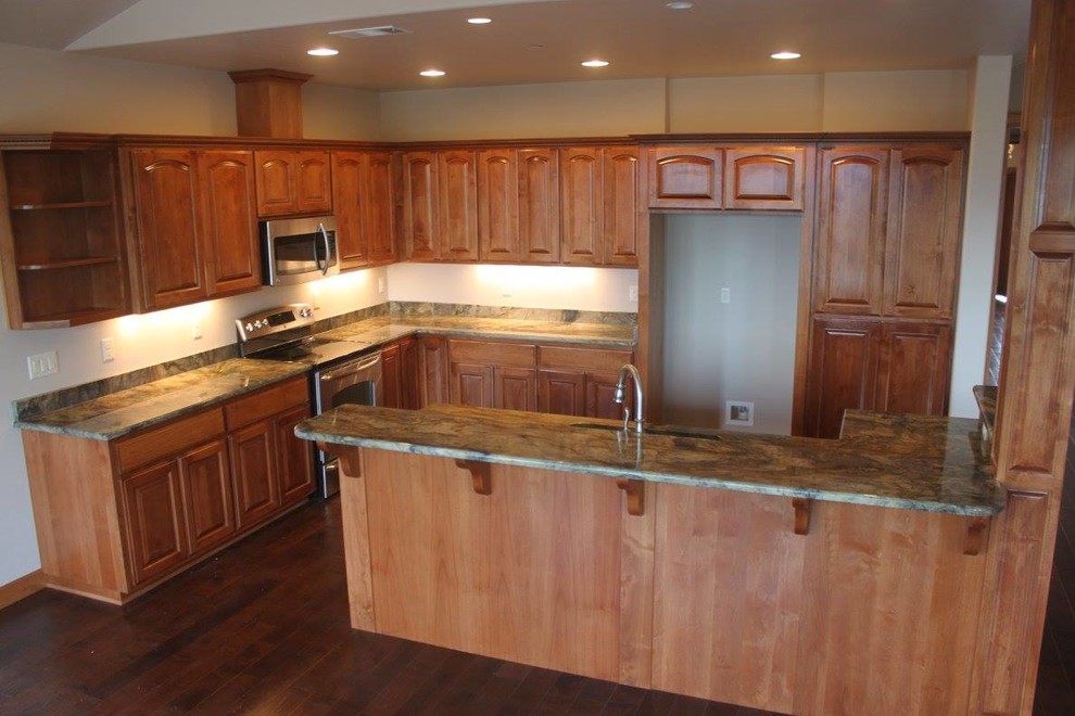 Kitchen - large contemporary l-shaped dark wood floor and brown floor kitchen idea with raised-panel cabinets, medium tone wood cabinets, granite countertops, stainless steel appliances and an island