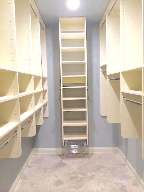 This is an example of a large traditional women's walk-in wardrobe in New Orleans with open cabinets, white cabinets and marble floors.