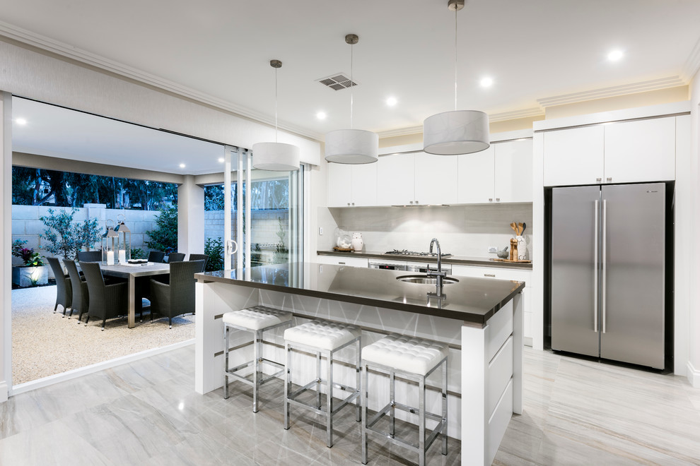 Photo of a contemporary galley kitchen in Perth with an undermount sink, flat-panel cabinets, white splashback, stainless steel appliances and with island.