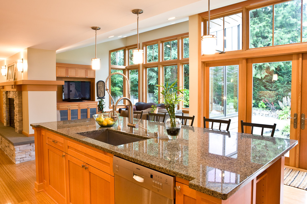 Contemporary open plan kitchen in Seattle with stainless steel appliances, an undermount sink, shaker cabinets and medium wood cabinets.