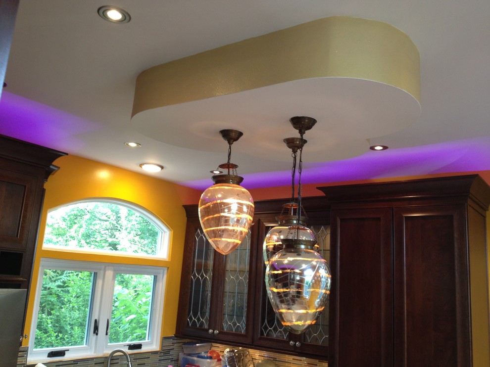 Example of a large transitional u-shaped porcelain tile home design design in Newark with a farmhouse sink, recessed-panel cabinets, red cabinets, granite countertops, beige backsplash, mosaic tile backsplash, stainless steel appliances and an island