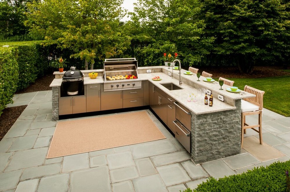 Inspiration for a large traditional backyard patio in New York with an outdoor kitchen, an awning and concrete pavers.