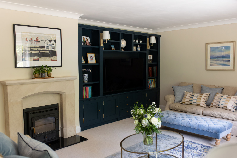 Mittelgroßes Landhausstil Wohnzimmer mit beiger Wandfarbe, Teppichboden, Kaminofen, Kaminumrandung aus gestapelten Steinen und beigem Boden in Kent