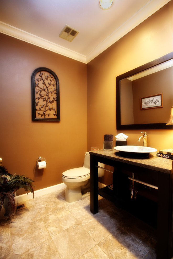 This is an example of a small transitional 3/4 bathroom in St Louis with a vessel sink, open cabinets, black cabinets, onyx benchtops, a two-piece toilet, beige tile, glass tile, beige walls and porcelain floors.
