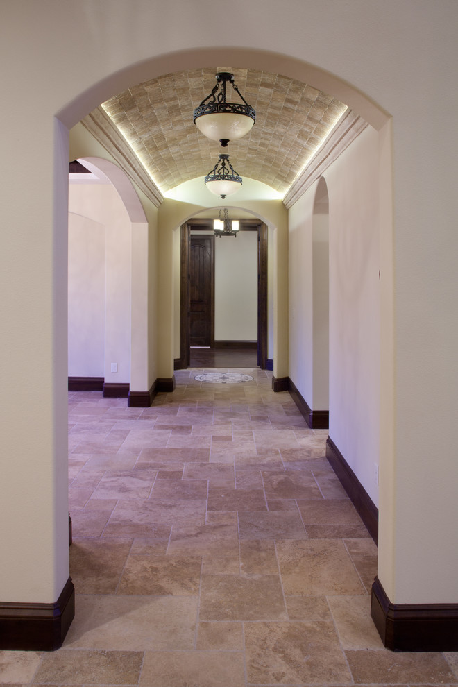 Inspiration for a mid-sized mediterranean hallway in Orlando with white walls and travertine floors.