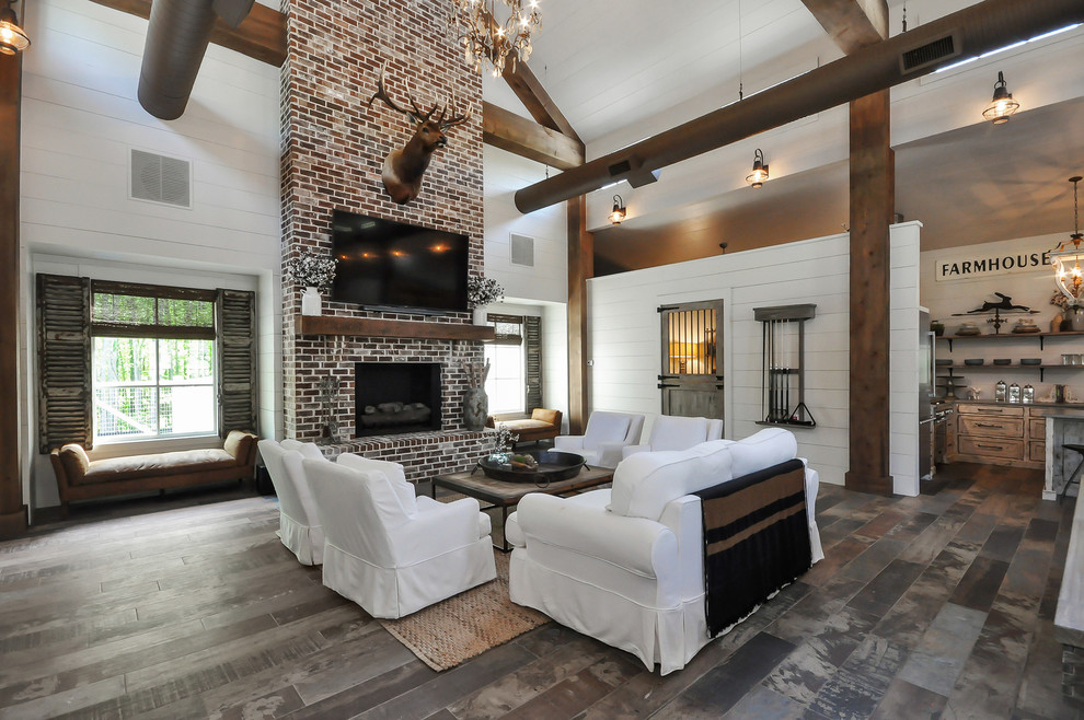 This is an example of a country living room in Atlanta with white walls, a wall-mounted tv, a standard fireplace, a brick fireplace surround and multi-coloured floor.