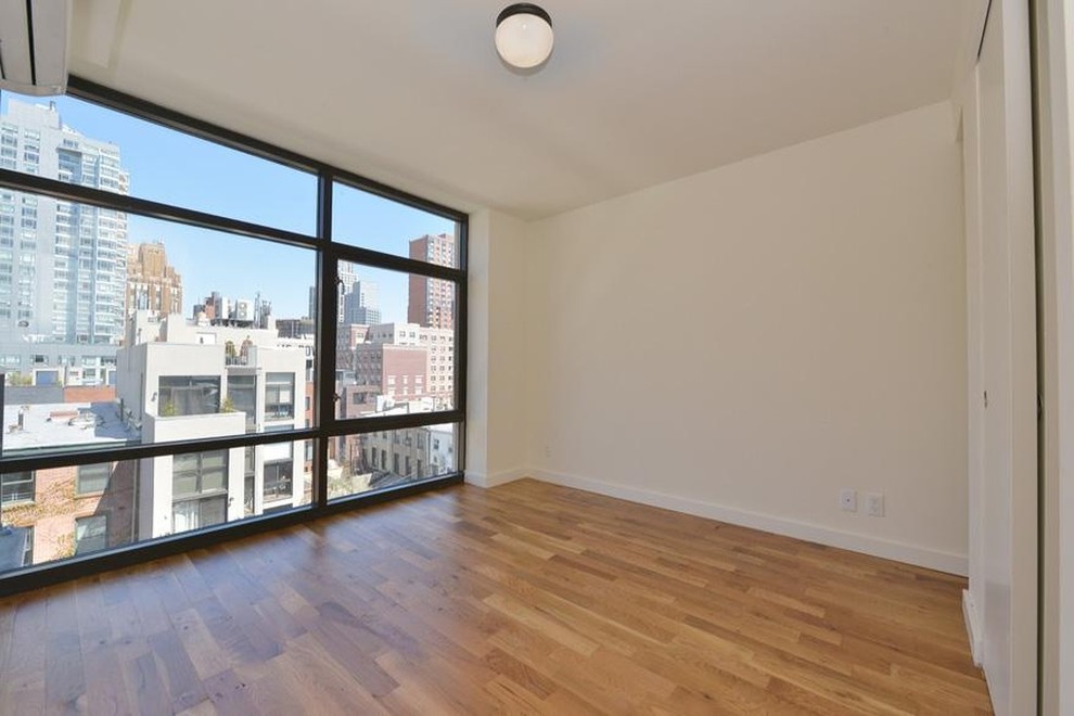 Mid-sized modern master bedroom in New York with white walls, light hardwood floors and no fireplace.