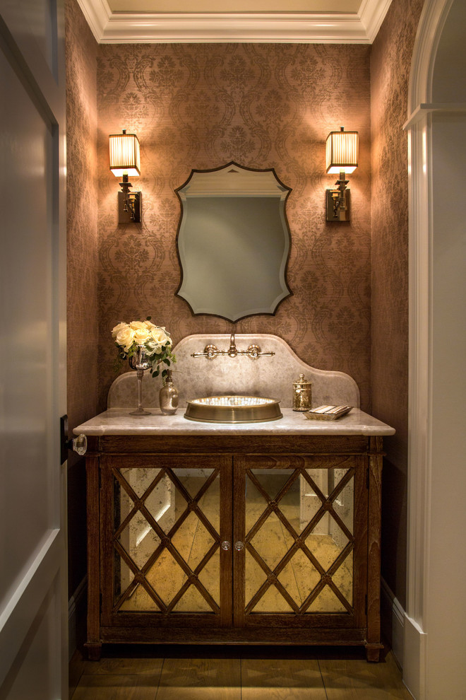 This is an example of a traditional powder room in Orange County with a vessel sink, furniture-like cabinets and dark wood cabinets.