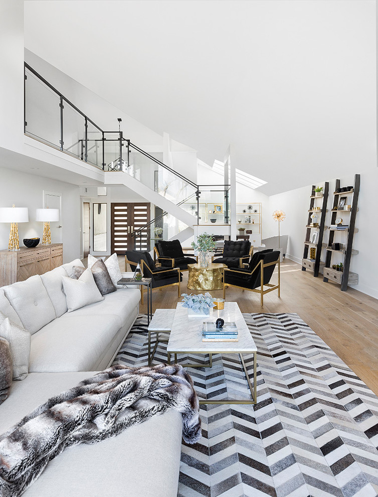 Inspiration for a mid-sized transitional open concept living room in Los Angeles with white walls, light hardwood floors, a wall-mounted tv and beige floor.