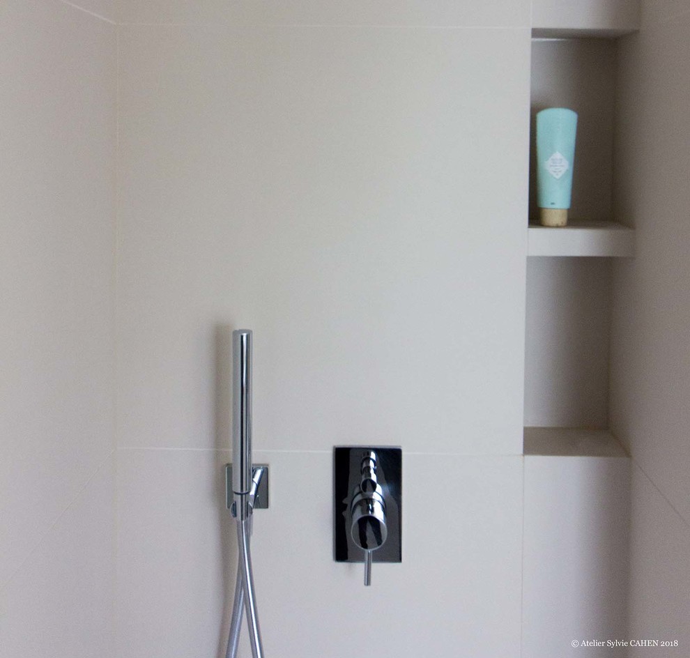 Cette image montre une petite salle d'eau design avec un placard à porte plane, des portes de placard blanches, une douche ouverte, WC suspendus, un carrelage beige, des carreaux de céramique, un mur beige, un sol en carrelage de céramique, un lavabo suspendu, un sol blanc, un plan de toilette beige, une niche et meuble-lavabo suspendu.
