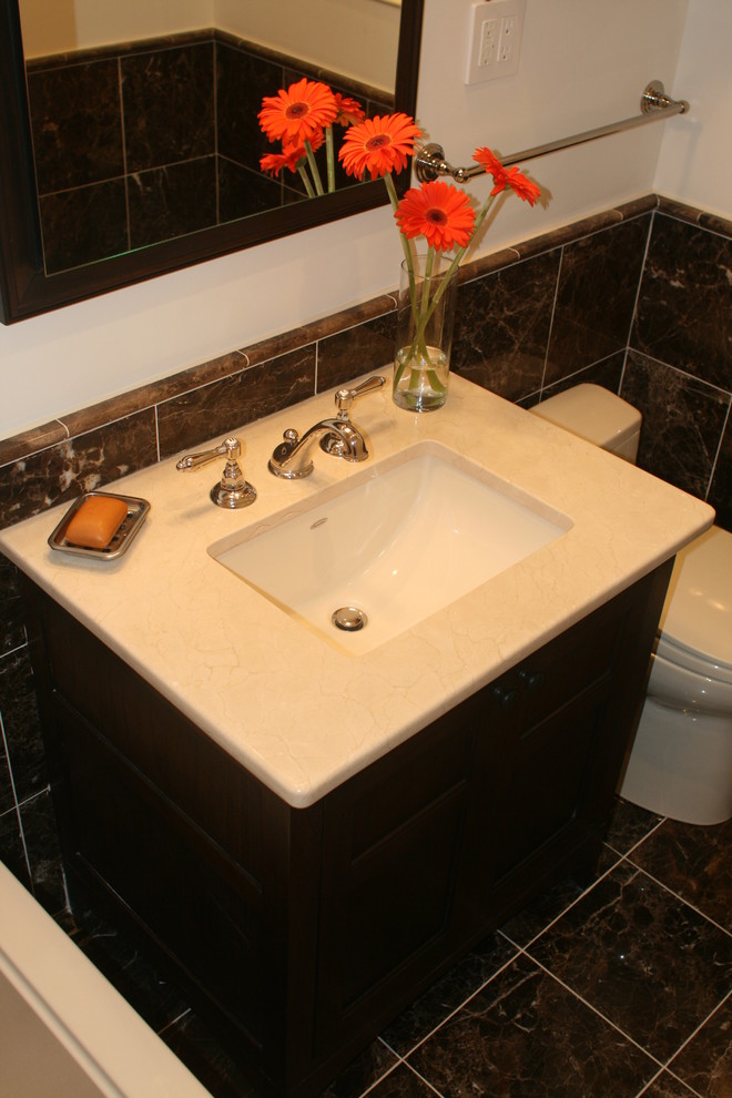 Small transitional master bathroom in New York with an undermount sink, furniture-like cabinets, dark wood cabinets, marble benchtops, a shower/bathtub combo, a one-piece toilet, brown tile, stone tile, brown walls, marble floors, an alcove tub, brown floor, an open shower, beige benchtops, a niche, a single vanity, a freestanding vanity and vaulted.