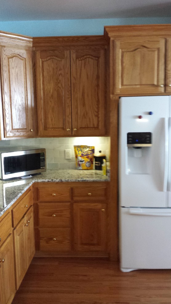 Example of a transitional kitchen design with shaker cabinets, white cabinets and an island