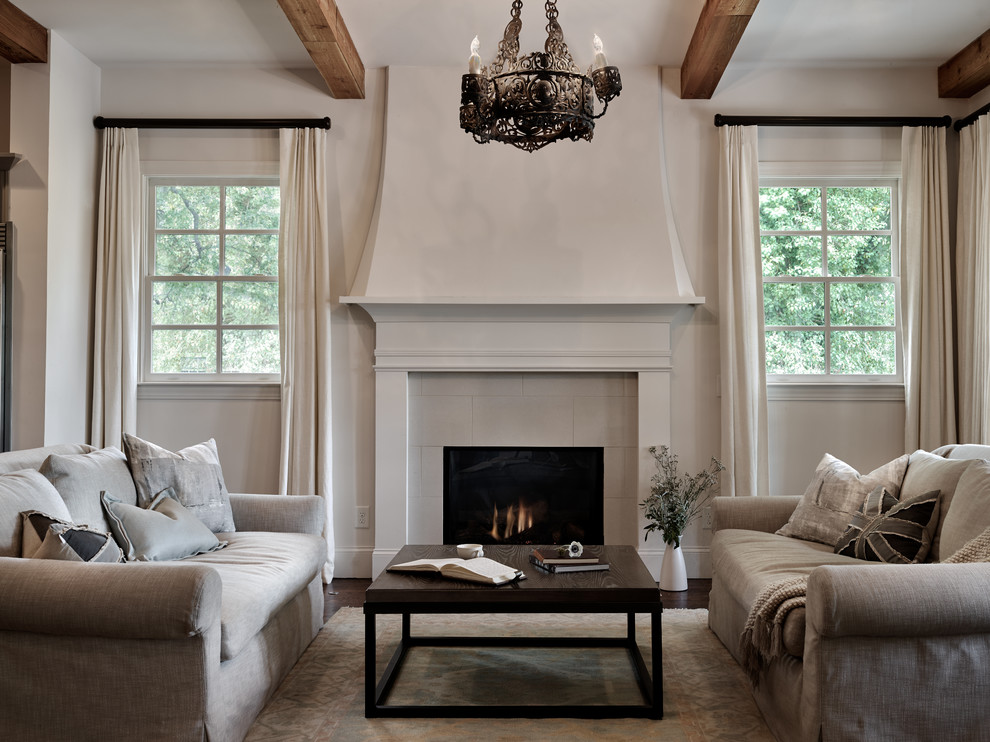 This is an example of a large mediterranean open concept living room in Nashville with medium hardwood floors, a standard fireplace and a tile fireplace surround.