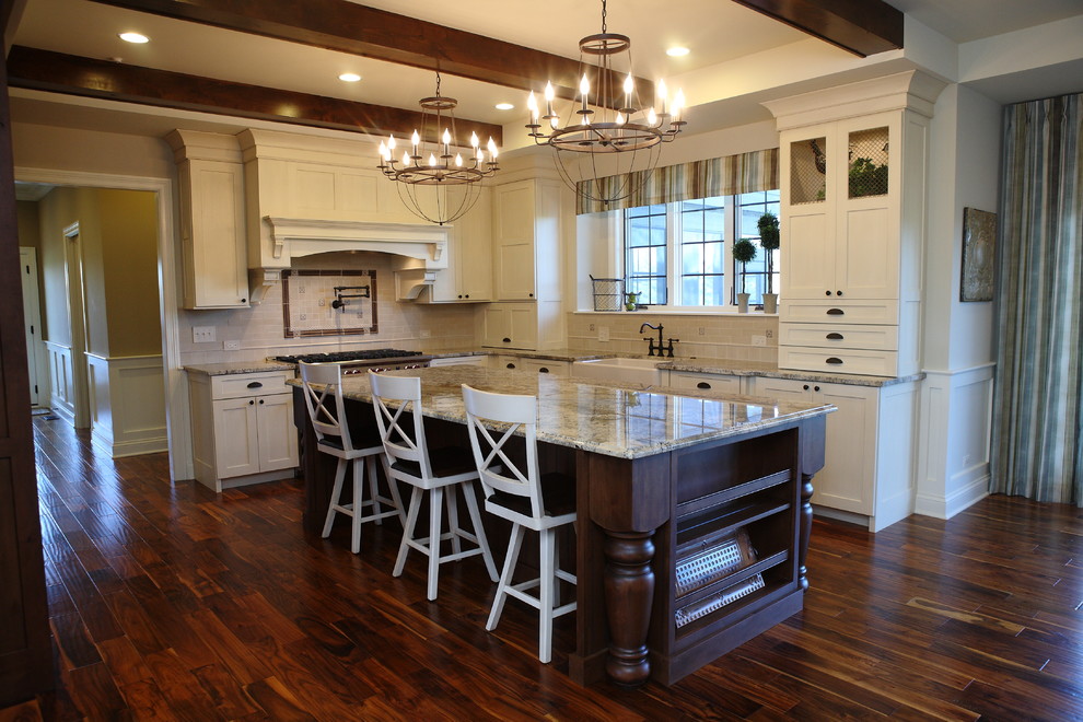 Photo of a mid-sized country l-shaped eat-in kitchen in Detroit with a farmhouse sink, shaker cabinets, white cabinets, granite benchtops, beige splashback, stainless steel appliances, dark hardwood floors, with island and brown floor.