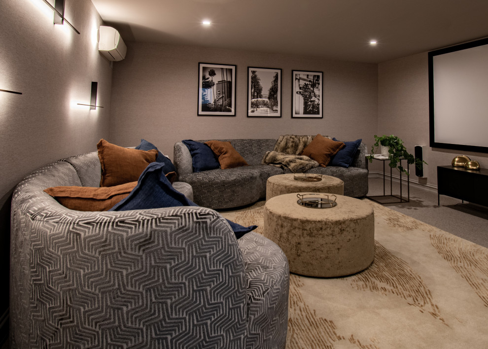 This is an example of a transitional home theatre in Melbourne with beige walls, carpet and grey floor.